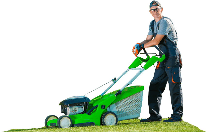 A person in work attire operates a bright green lawn mower on freshly cut grass, showcasing a clean, well-maintained yard.