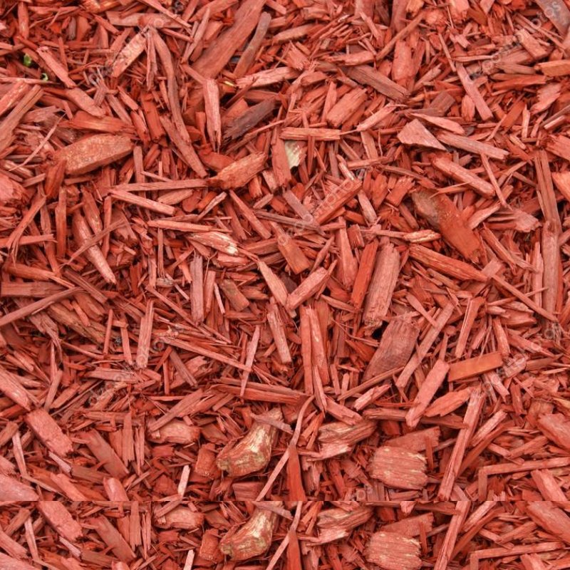 Close-up of finely shredded red mulch, creating a textured and vibrant ground cover for landscaping and garden beds.